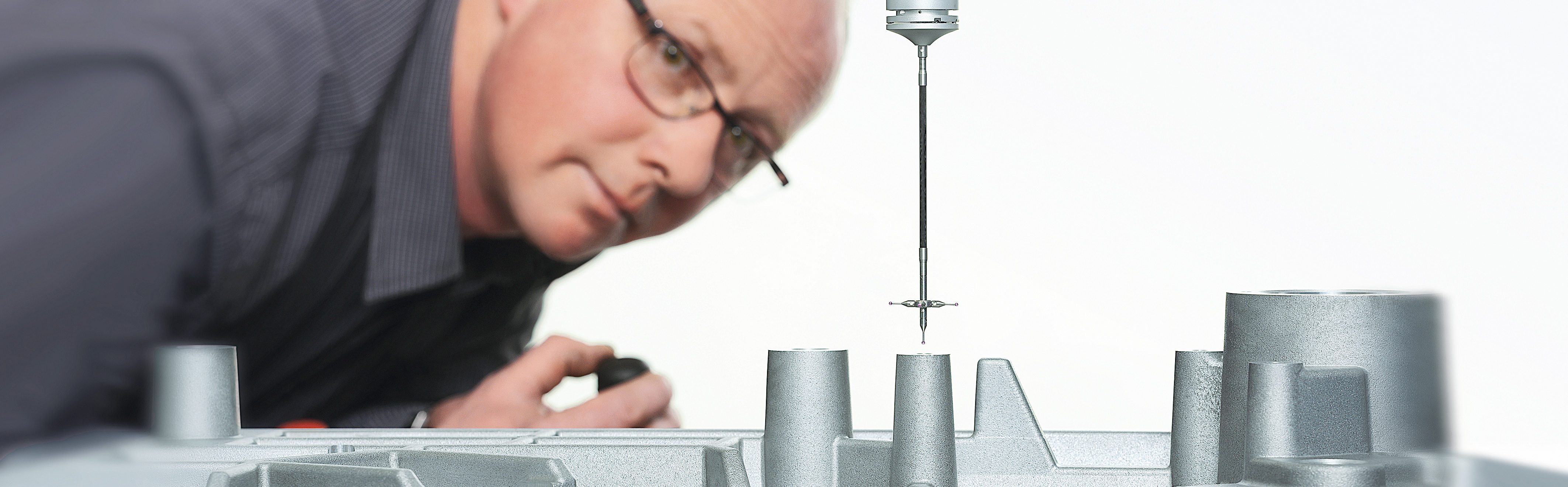 Teil einer Meßmaschine SAHM Qualitätsmanagement-Mitarbeiter, der ein Detail einer Meßmaschine betrachtet.